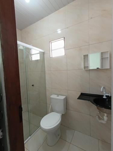 a bathroom with a toilet and a shower and a sink at CASAS com PISCINA SENSACIONAIS NO CENTRO - Residencial Tchê in Barreirinhas