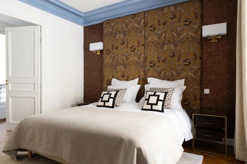 une chambre avec un grand lit avec deux oreillers dans l'établissement Champs Élysées Montaigne Luxury 2 bedroom, à Paris