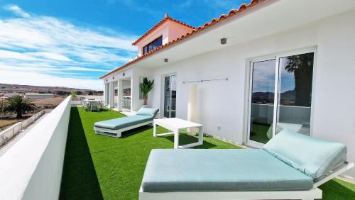 a patio with green grass and a white house at Casa do Pico by Casas dos Lebre in Porto Santo