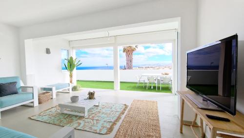 a living room with a large tv and a view of the ocean at Casa do Pico by Casas dos Lebre in Porto Santo
