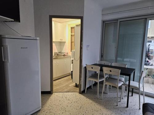une cuisine et une salle à manger avec une table et des chaises dans l'établissement Gruissan plage des chalets petit logement en rdc, à Gruissan