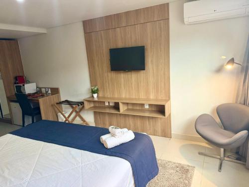 una camera con letto, TV e sedia di Studio 107 - Moderno no Granja Brasil em Itaipava a Petrópolis