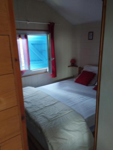 a mirror reflection of a bedroom with two beds and a window at Chalet gîte des hauts moriers in Vaas
