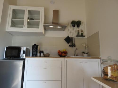 a kitchen with white cabinets and a microwave at Antico Podere San Luca in Bologna