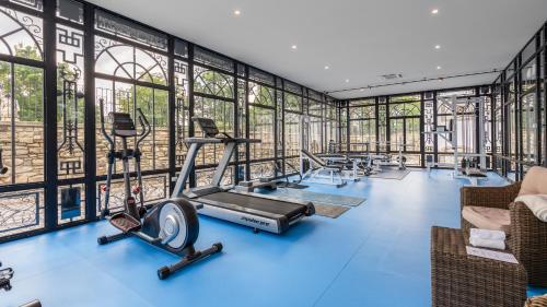 a gym with blue flooring and glass walls at Galicia Nueva, castle hotel in Lučenec