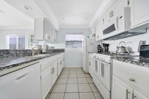 a white kitchen with white cabinets and appliances at 1404 W Oceanfront A in Newport Beach