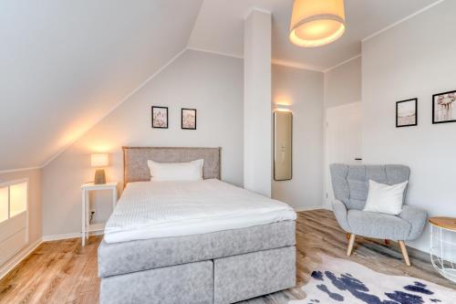 a bedroom with a bed and a chair at One Moment Boardinghouse - Porta Westfalica in Porta Westfalica