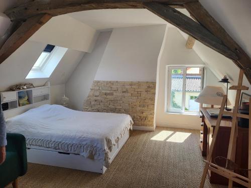a bedroom with a bed and a brick wall at blu dragonfly in Saint-Aubin-sur-Loire