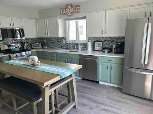 a kitchen with green cabinets and a wooden table at Seaside Serenity AC-Beautiful Ocean View Home -3 bed 2 bath in Atlantic City