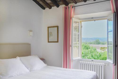 a bedroom with a bed and a large window at Hôtel La Figuière in Saint-Tropez
