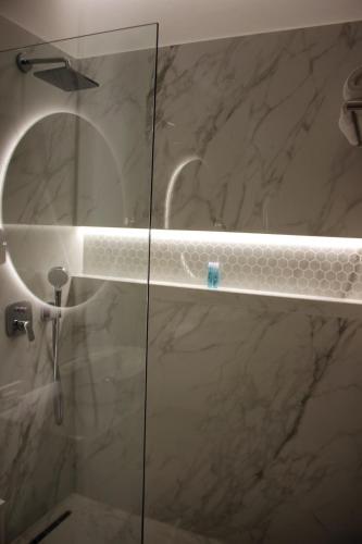 a bathroom with a shower with a glass door at Hotel Monarch in Elbasan