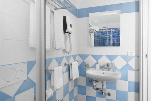 a bathroom with blue and white tiles and a sink at Al Centro Suites in Sorrento