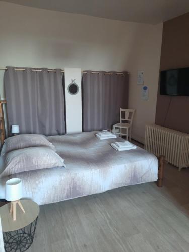 a bedroom with a large bed and a table at La Maison Genevier - Chambre Doréline in Montreuil-en-Touraine