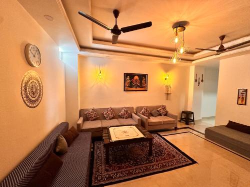 a living room with a couch and a ceiling fan at Yoga Retreat at The Ganges in Rishikesh in Rishīkesh