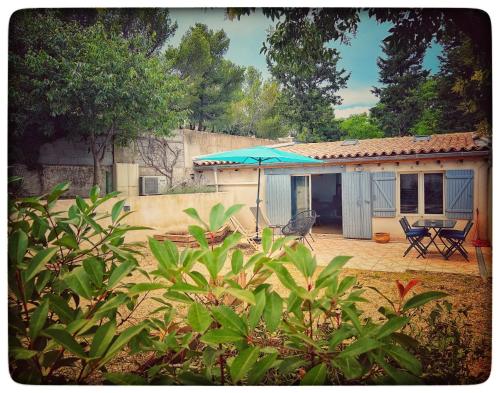 Cette maison dispose d'une terrasse avec un parasol et des chaises. dans l'établissement Maison des garçons, à Villeneuve-lès-Avignon