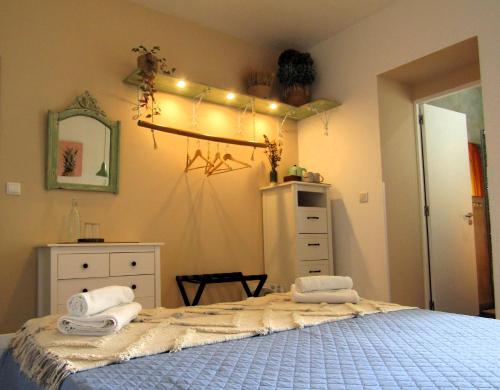 a bedroom with a bed with towels on it at A-Típica GuestHouse in Ponta Delgada