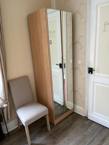 a chair and a mirror in a room at Le Pontet in Miramont-de-Guyenne