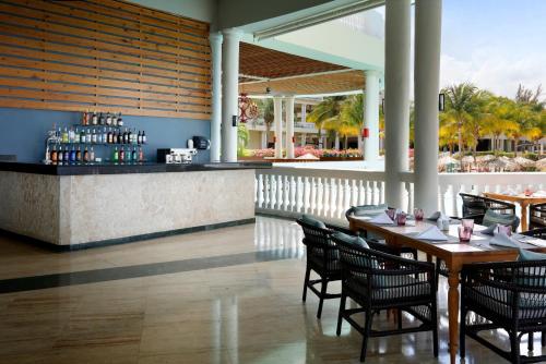 a restaurant with tables and chairs and a bar at The Signature Level at Grand Palladium Lady Hamilton Resort & Spa- All Inclusive in Lucea