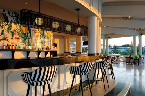 a bar with black and white chairs at a resort at The Signature Level at Grand Palladium Lady Hamilton Resort & Spa- All Inclusive in Lucea