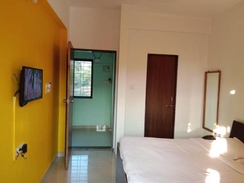 a bedroom with a bed and a door to a bathroom at Hotel Nandanvan by Royal Stay in Lonavala