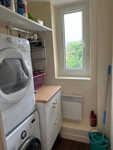 une cuisine avec une machine à laver et une fenêtre dans l'établissement Cocon contemporain et confortable proche Paris, à Alfortville