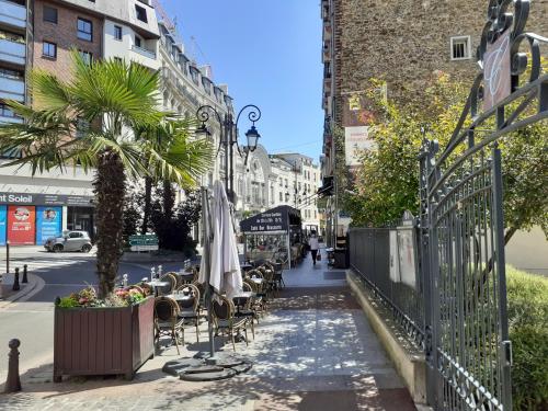 a sidewalk with chairs and umbrellas on a city street at Maison individuelle avec terrasse Nogent sur Marne in Nogent-sur-Marne