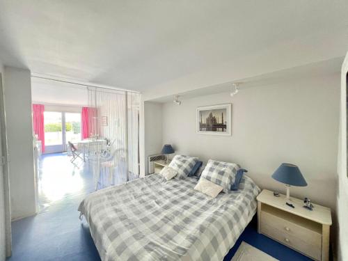 une chambre avec un lit et une table avec une lampe dans l'établissement Logement avec accès direct à la mer à La Tranche-sur-Mer, à La Tranche-sur-Mer