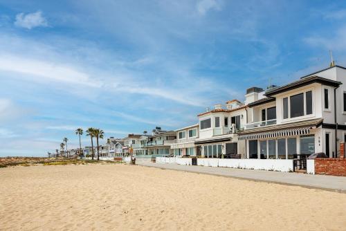 a row of houses on a beach with palm trees at 204 E Oceanfront A in Newport Beach