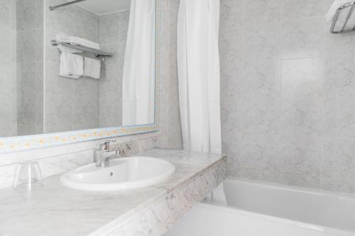 a bathroom with a sink and a bath tub at Apartamentos Balear Beach in Palmanova