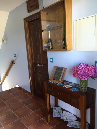a room with a table with a vase of flowers on it at Apartamentos rurales la Aguilera in Oviñana