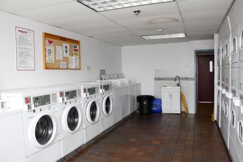 a laundry room with four washing machines in it at Neill Wycik Hotel in Toronto