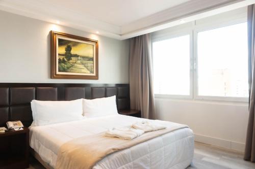 a bedroom with a bed with towels on it at Plaza São Rafael Hotel in Porto Alegre