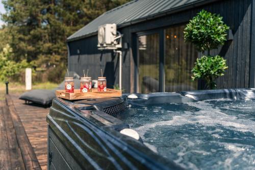 a hot tub with drinks on top of it at Paežerės istorijos, Druskininkai in Veršiai