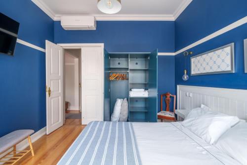 a blue bedroom with a bed and a blue wall at Apartamentos T1 de charme - Pombal, Centro Histórico in Pombal