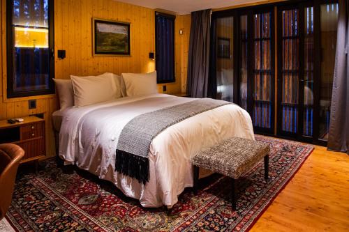 a bedroom with a large bed and a rug at LAS LIEBRES RESTAURANT & HOTEL in Colonia del Sacramento