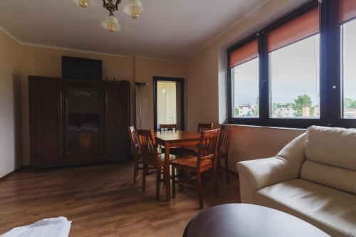 salon ze stołem, krzesłami i kanapą w obiekcie Apartamenty Wilk w Łebie
