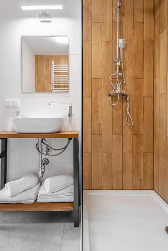 a bathroom with a sink and a mirror and a tub at Przystań Jeziorany - willa nad jeziorem - Warmia i Mazury in Jeziorany