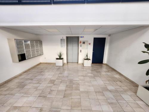 an empty room with two potted plants on the wall at NEW with AC Central Suites with Pool access and Squash Courts! Sleeps Family or 4 guests in Gibraltar