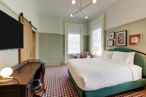 a hotel room with a bed and a flat screen tv at Trilogy Hotel Montgomery, Autograph Collection in Montgomery