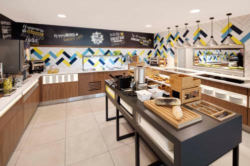 a restaurant kitchen with a counter with food at Hampton By Hilton London Stansted Airport in Stansted Mountfitchet