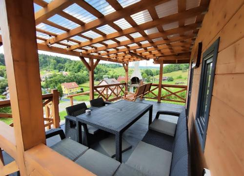 Un patio con una mesa y sillas en una terraza. en Chatka Niedźwiadka, en Bezmichowa Dolna