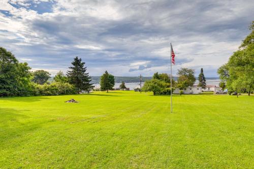 a field with an american flag in the grass at Keuka Lake Cabin with Boat Dock Access and Fire Pit! in Hammondsport