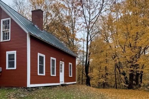a red house with trees in the background at Starry Plough in Bridgewater
