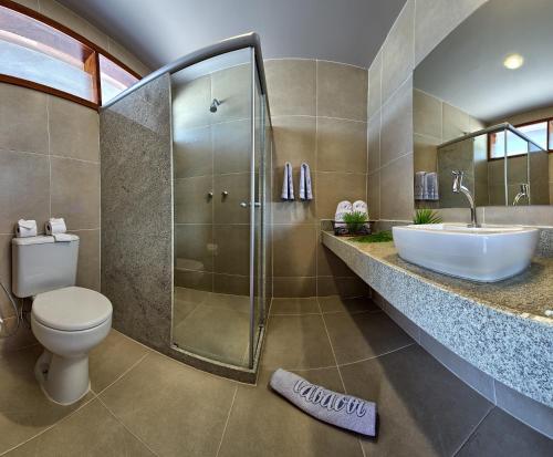 a bathroom with a shower and a toilet and a sink at Tabaobí Smart Hotel in Porto De Galinhas