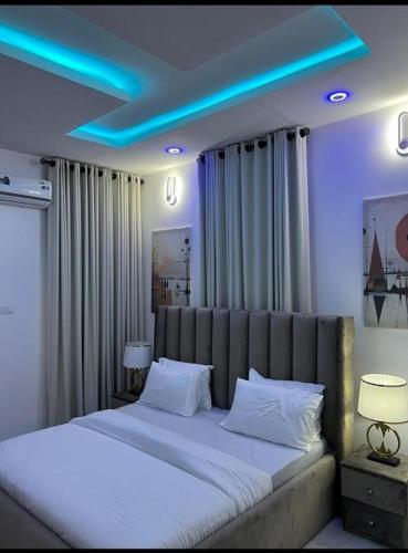 a bedroom with a large bed with blue lights on it at Eco Luxury Apartment in Lekki