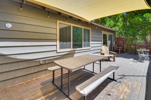 a patio with a table and a bench on a house at Cozy Retreat with Deck about 2 Mi to Pinecrest Lake! in Strawberry
