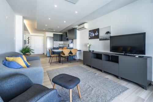 a living room with a couch and a flat screen tv at Deluxe Seaview Apartment in St. Julianʼs