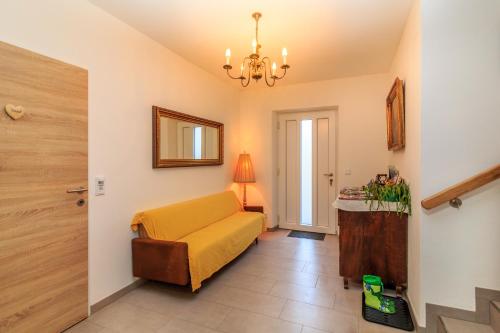 a living room with a yellow couch and a table at Wittinghof in Julbach
