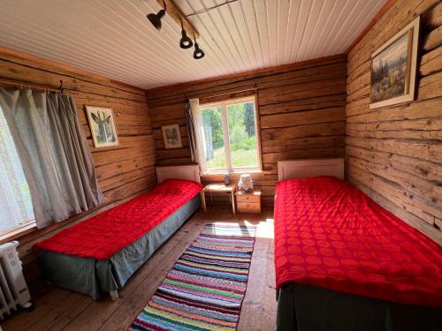 a room with two beds in a log cabin at Haanjanaise talu in Haanja