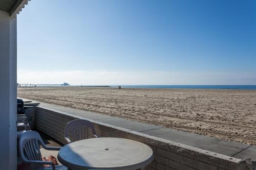 a table and chairs on a balcony looking at the beach at 3112 W Oceanfront A in Newport Beach